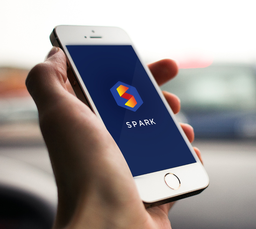 iPhone in hand showing the Spark app splash screen